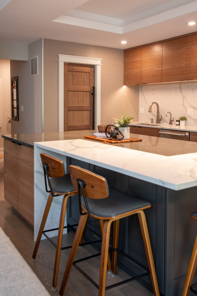 Deerfield Cohesive Contemporary Kitchen Remodel after 13. Photo of the island seating looking towards the entryway.